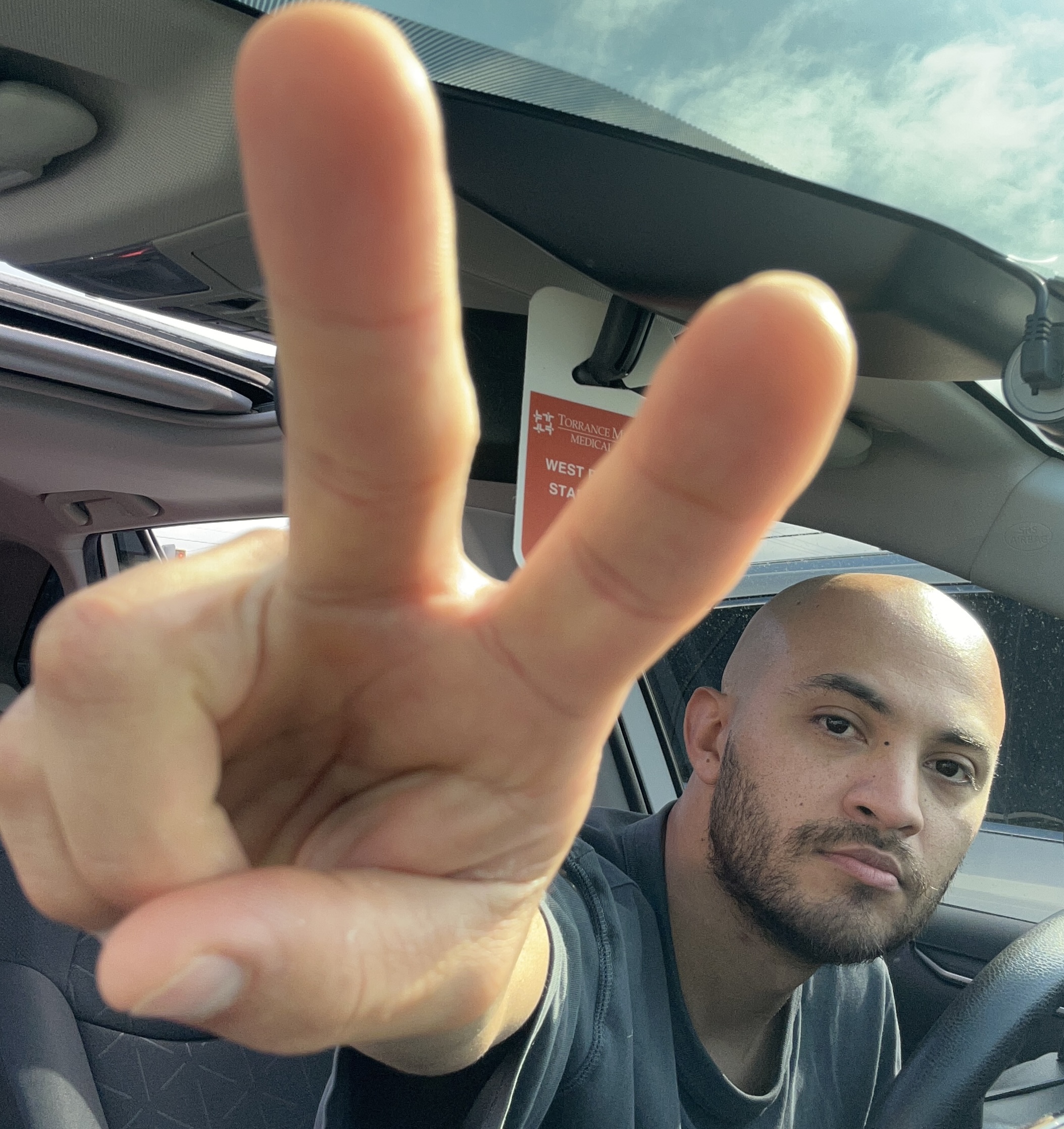 christian ventura flashing a peace sign selfie inside a car